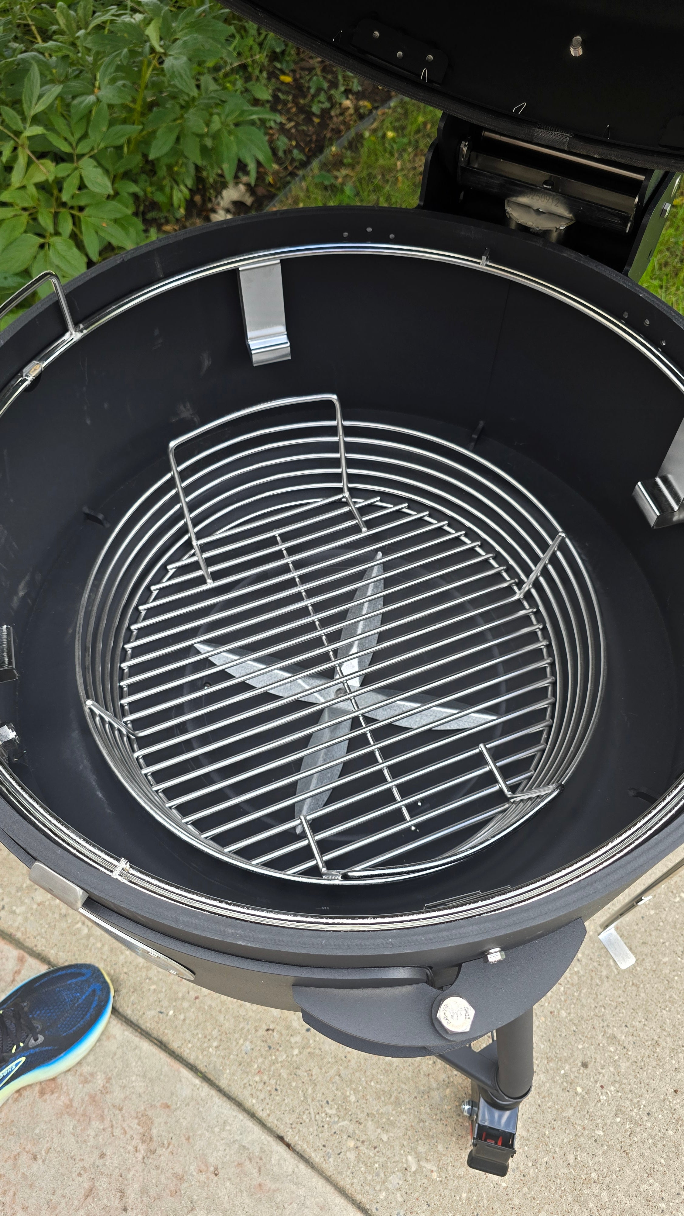 A Spider Huntsman grill with its lid open, showing a 17 inch Kick ash Basket inside. There is 1 to 2 inches of space between the basket and the grill