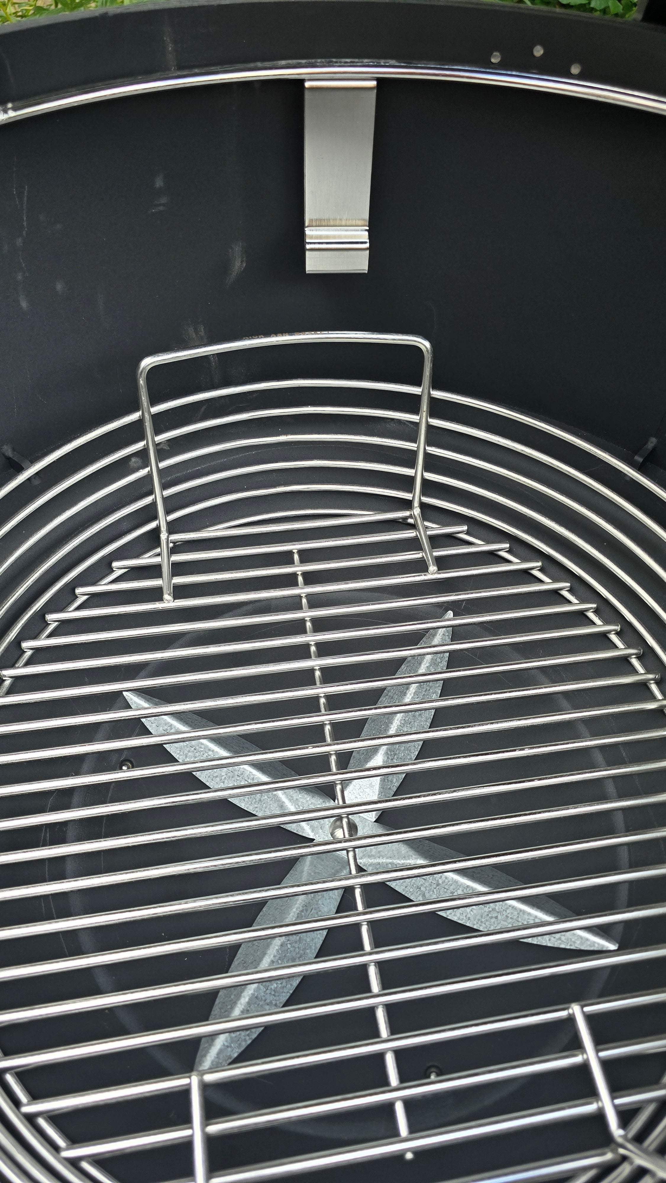 A Spider Huntsman grill with its lid open, showing a 17 inch Kick ash Basket inside. The basket handle is 2 inches below the secondary grate ledge