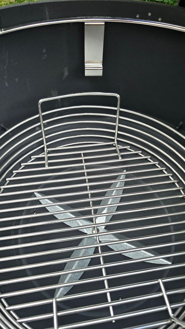 A Spider Huntsman grill with its lid open, showing a 17 inch Kick ash Basket inside. The basket handle is 2 inches below the secondary grate ledge