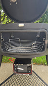 A Spider Huntsman grill with its lid open, showing a 17 inch Kick ash Basket inside. The view is from the side door of the grill.
