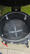 A top-down view of a Spider Huntsman grill with its lid open, showing a Kick Ash Basket inside.  KAB-BKT-C1912