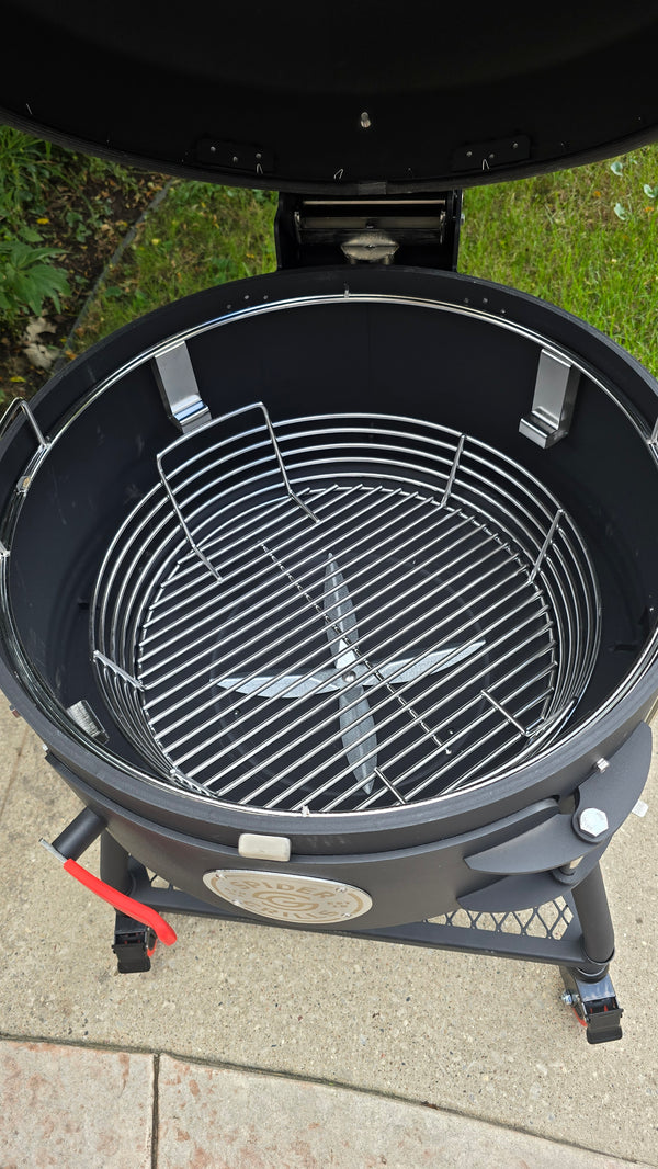 A Spider Huntsman grill with its lid open, showing a top view of a Kick Ash Basket, KAB-BKT-C1917
