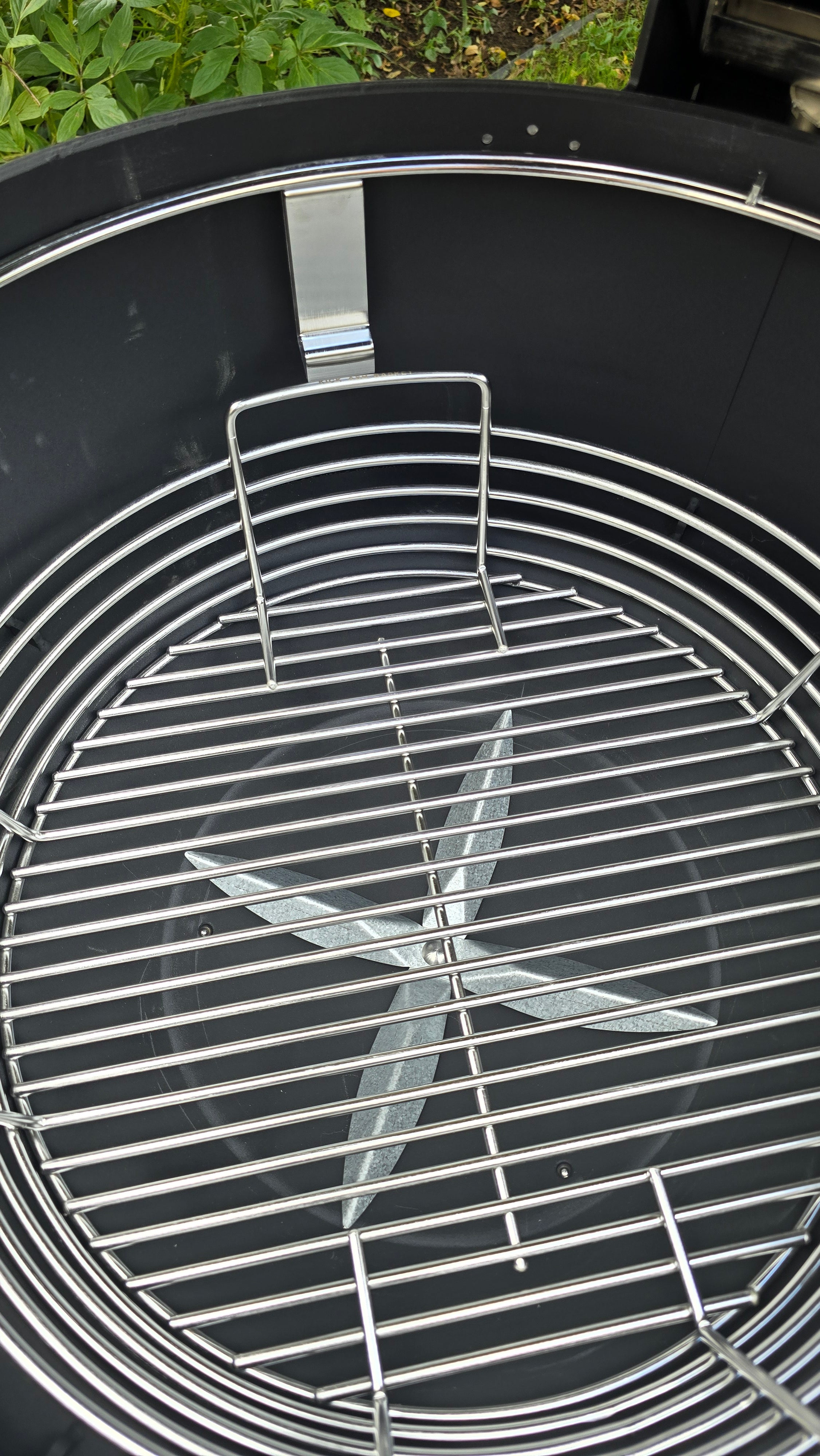 A Spider Huntsman grill with its lid open, showing a top view of a Kick Ash Basket, KAB-BKT-C1917