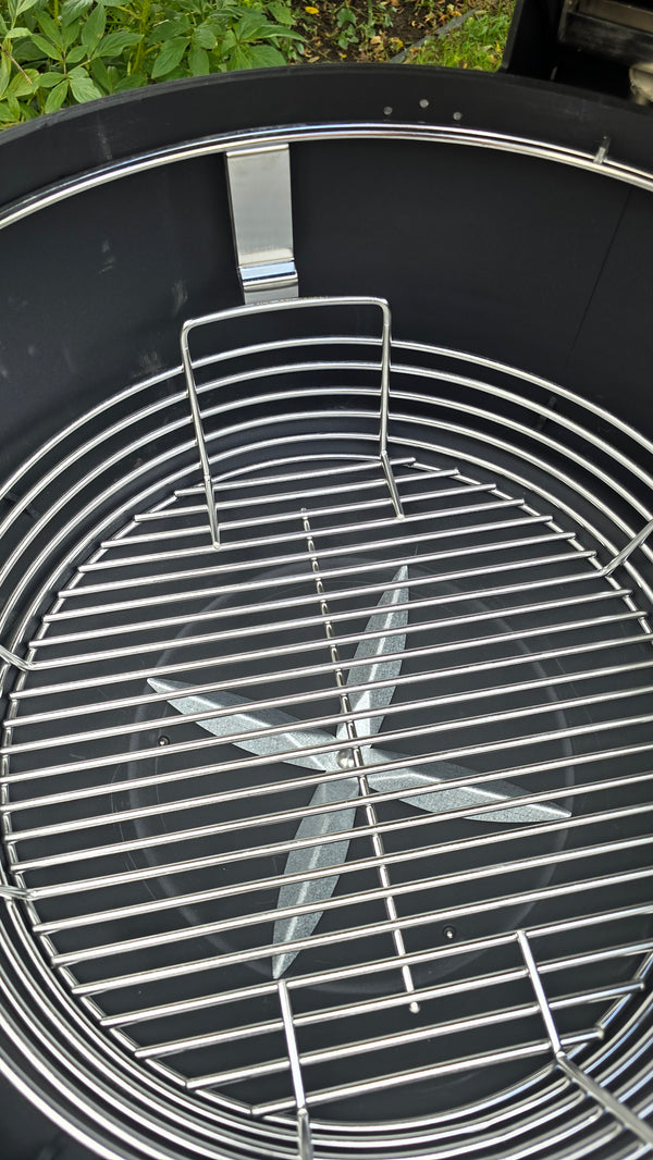 A Spider Huntsman grill with its lid open, showing a top view of a Kick Ash Basket, KAB-BKT-C1917